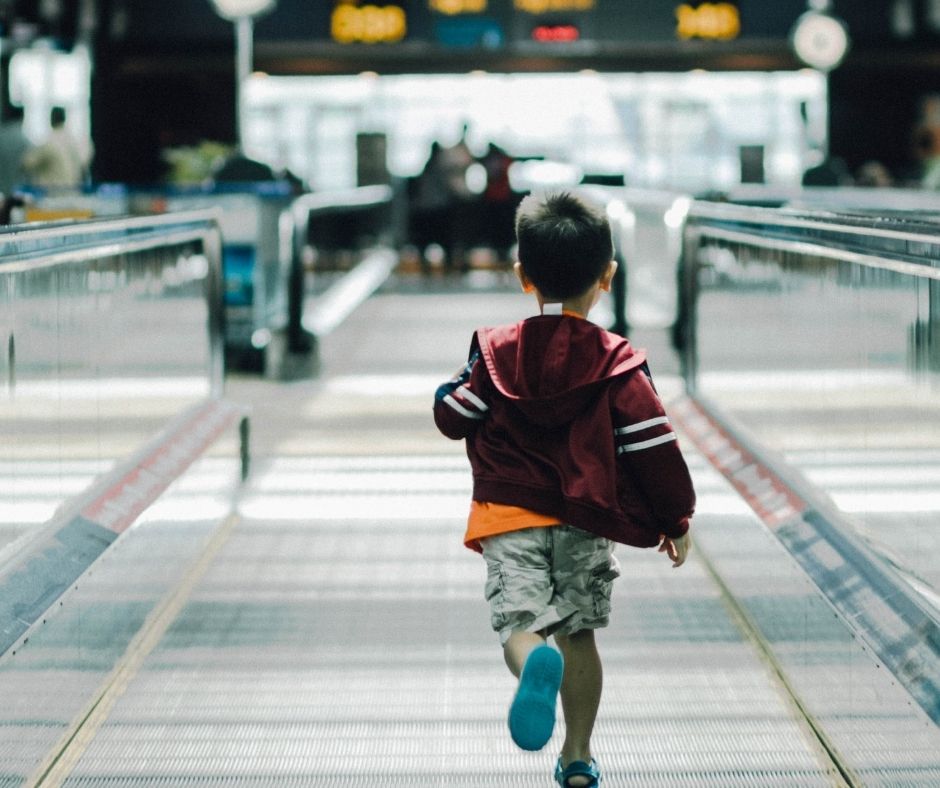 A young boy runs through an airport