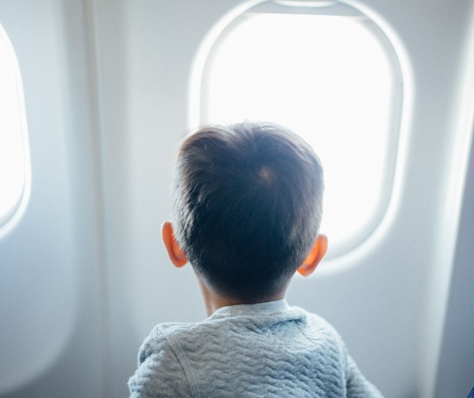 A child stares out the plane window.