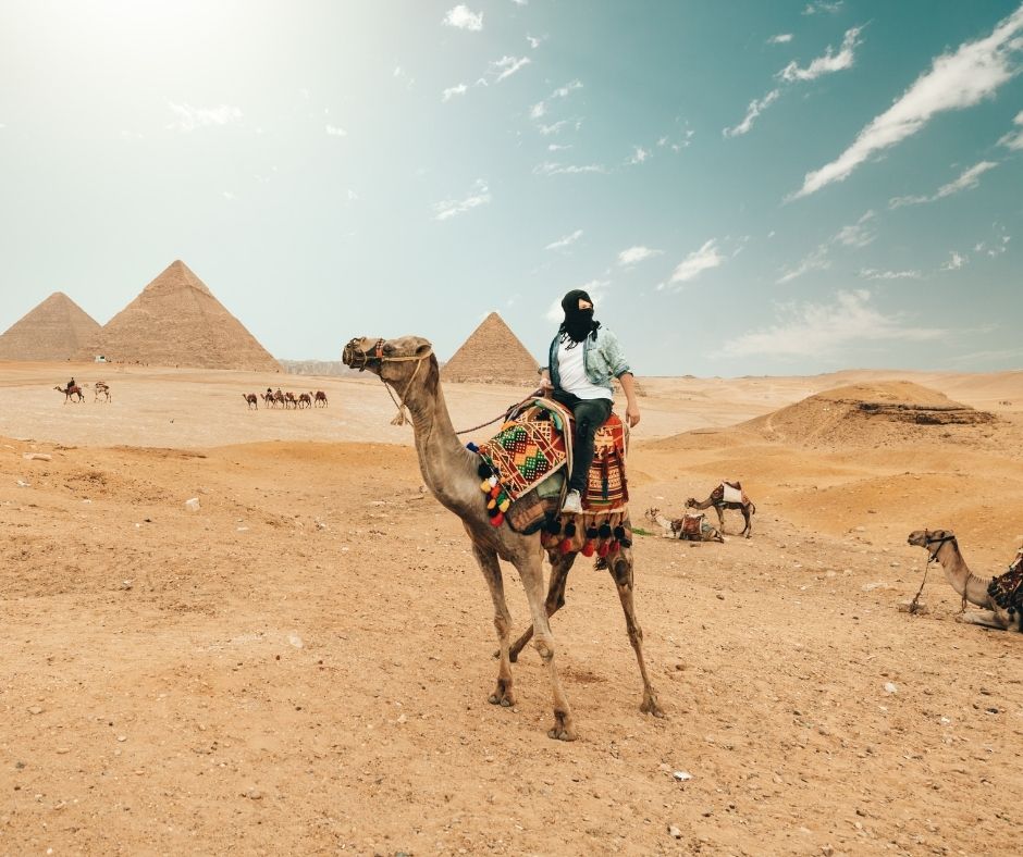 Riding a camel past the Pyramids of Giza is a key tourist attraction