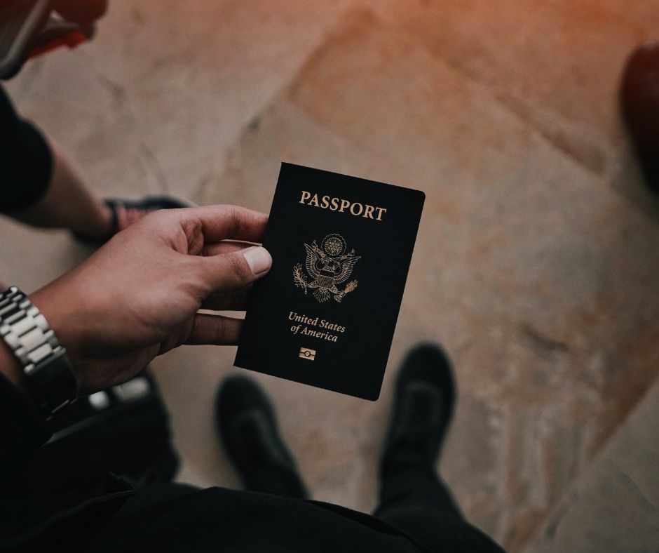 A man holds a passport from the United States of America